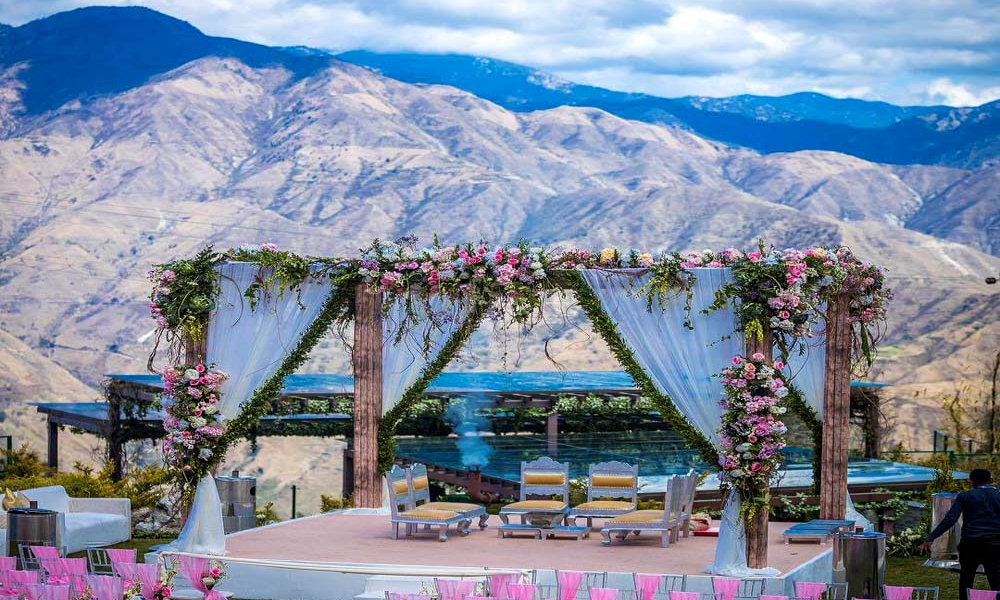 Bride and groom at a sunset beach ceremony with decor and guests — destination wedding cost in India