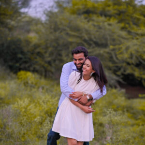 Couple holding each other in scenic open field during outdoor couple shoot