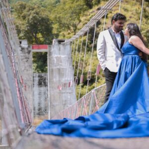 Bride posing near waterfall in long blue gown during pre wedding shoot